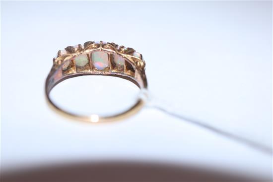 An early 20th century 18ct. gold, graduated five stone white opal and diamond chip half hoop ring, size O.